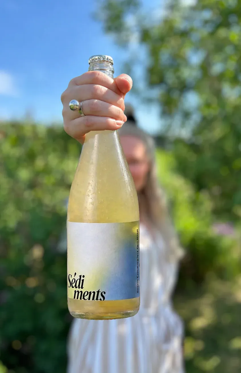Bouteille Sédiments tenue à la main, lumière d'été